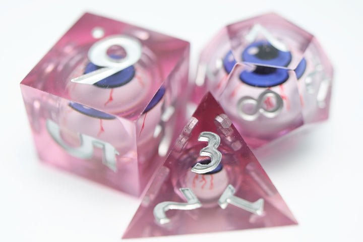 Sharp Edge Moving Eye RPG Dice Set - Bloodshot These super sharp edge dice are hand polished instead of tumbled to give them the shine without softening their edges. These dice are unique and each die in the set has a moving eye that's always looking up!  Perfect for Role Playing Games like Dungeons and Dragons (D&D), Shadowrun, Pathfinder, Warhammer, fantasy, sci-fi, or party games.   Details:  Set Type: 7 Piece RPG Set (D4, D6, D8, D10, D1%, D12, D20) Size: 16mm Material: Resin Color: Pink