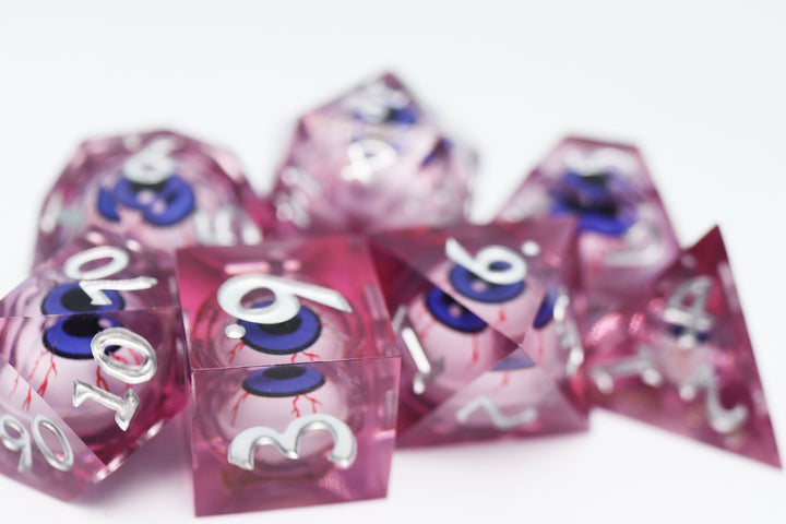 Sharp Edge Moving Eye RPG Dice Set - Bloodshot These super sharp edge dice are hand polished instead of tumbled to give them the shine without softening their edges. These dice are unique and each die in the set has a moving eye that's always looking up!  Perfect for Role Playing Games like Dungeons and Dragons (D&D), Shadowrun, Pathfinder, Warhammer, fantasy, sci-fi, or party games.   Details:  Set Type: 7 Piece RPG Set (D4, D6, D8, D10, D1%, D12, D20) Size: 16mm Material: Resin Color: Pink