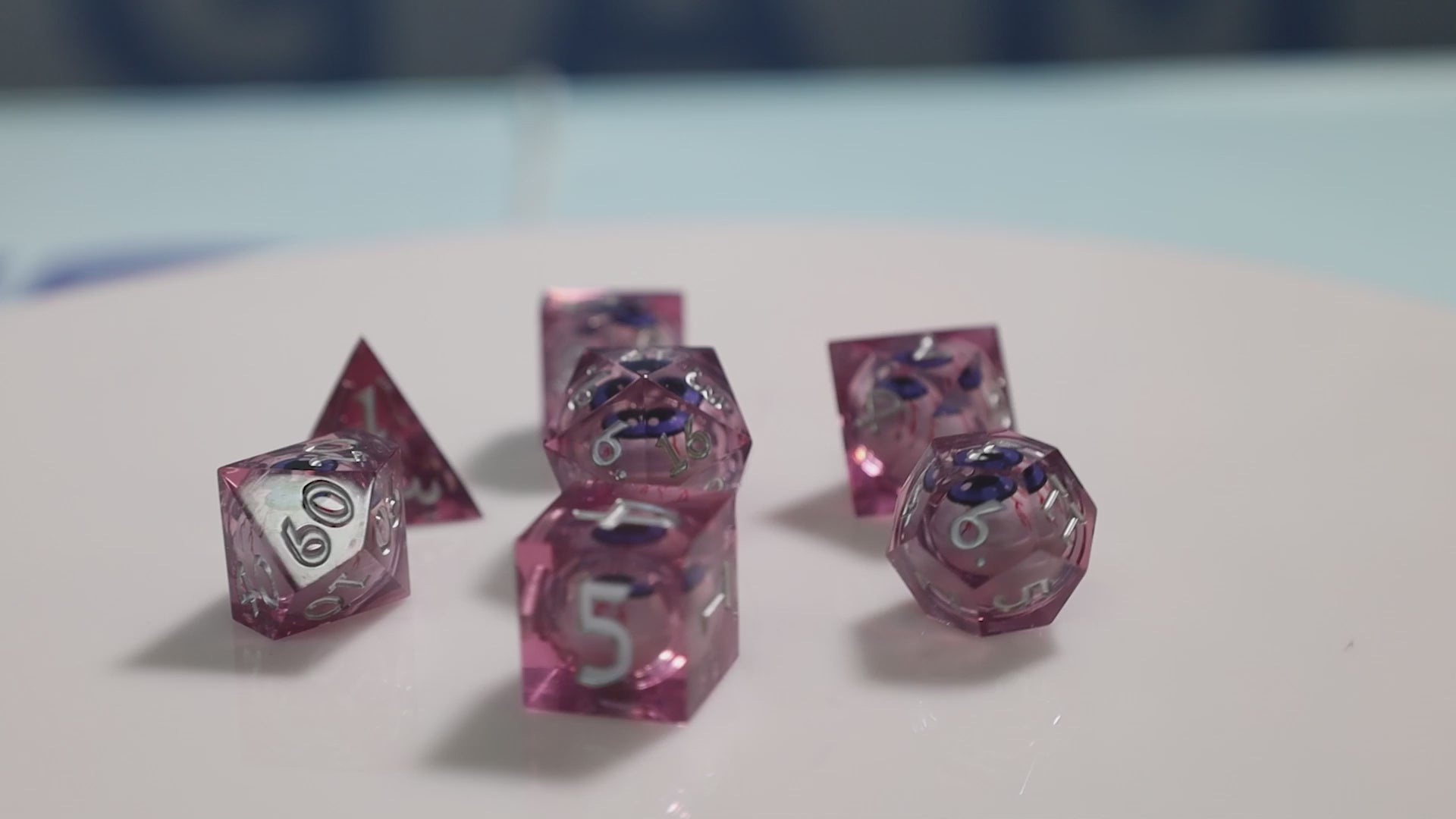 Sharp Edge Moving Eye RPG Dice Set - Bloodshot These super sharp edge dice are hand polished instead of tumbled to give them the shine without softening their edges. These dice are unique and each die in the set has a moving eye that's always looking up!  Perfect for Role Playing Games like Dungeons and Dragons (D&D), Shadowrun, Pathfinder, Warhammer, fantasy, sci-fi, or party games.   Details:  Set Type: 7 Piece RPG Set (D4, D6, D8, D10, D1%, D12, D20) Size: 16mm Material: Resin Color: Pink