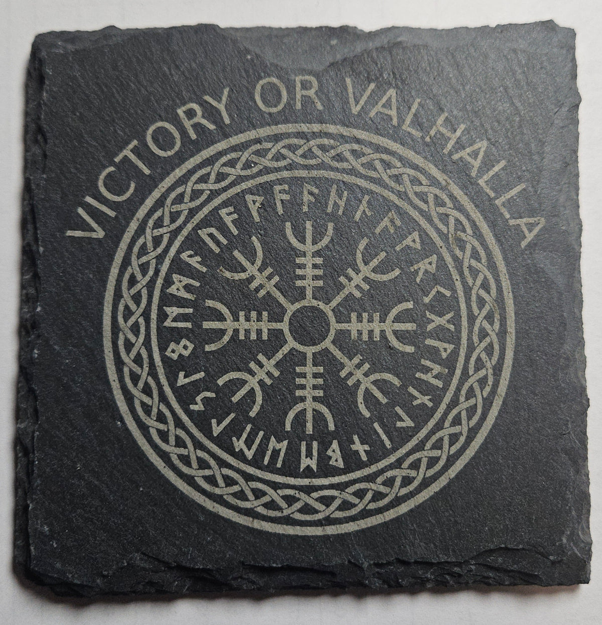 Slate stone with engraved symbol and 'Victory or Valhalla' text on a gray background